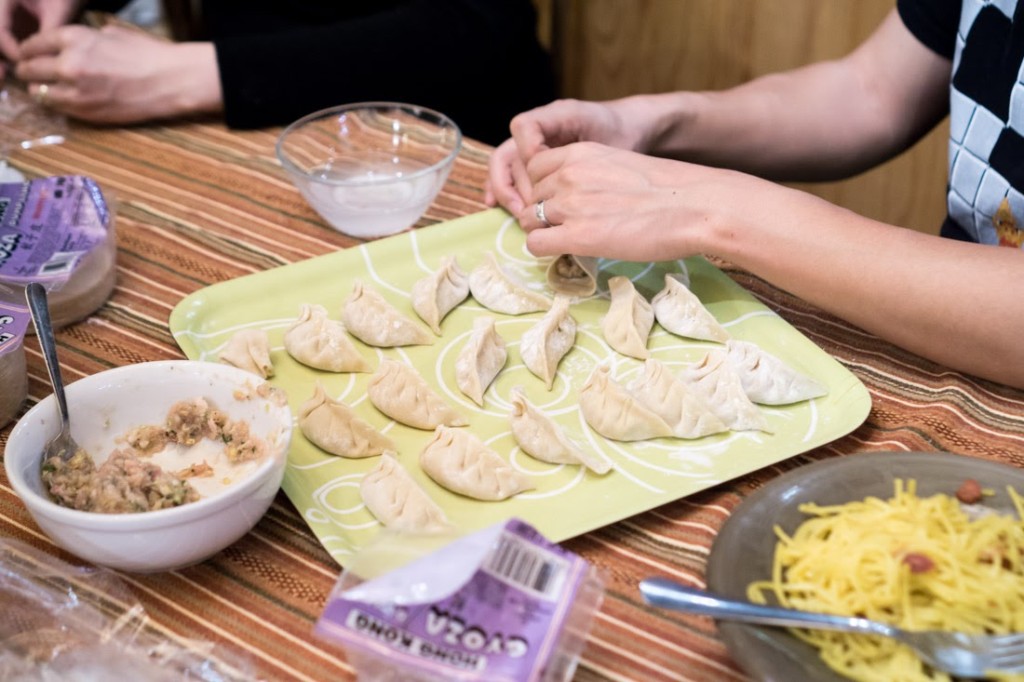 Wrapping dumplings with packaged dumpling dough. Notice the unique s-shaped style in the middle of the platter.