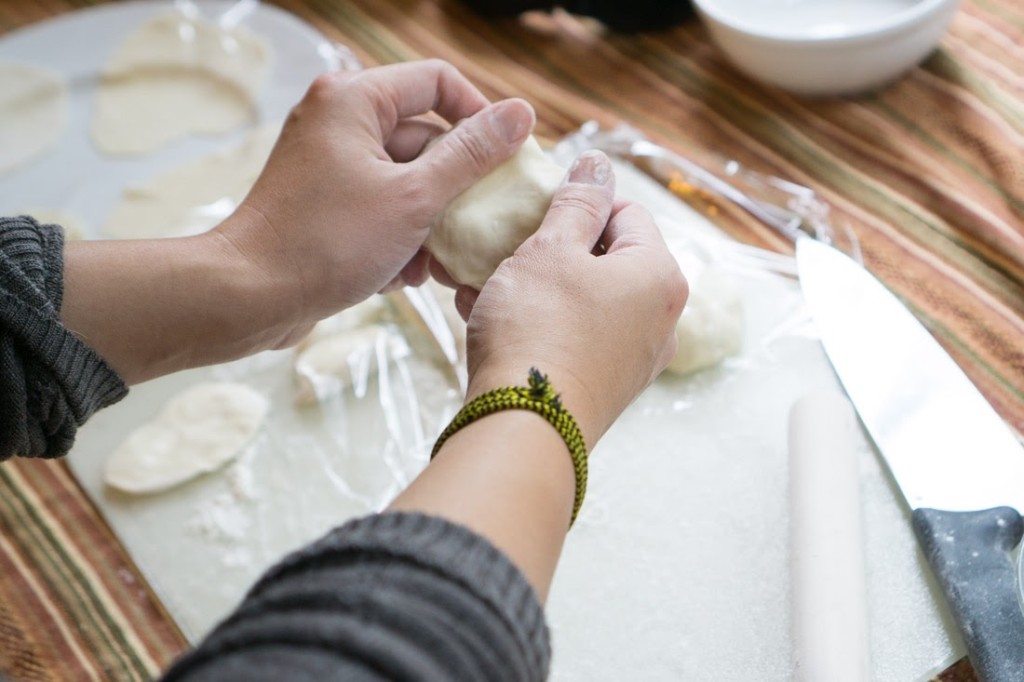 Gradually, my technique improved...(here, I'm pinching out the dough to create a more even round before rolling out the dough)