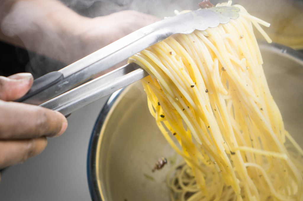 Quickly toss the hot pasta and bit of pasta water with the egg yolk-bacon mixture